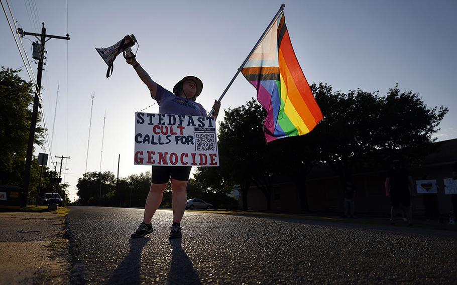 Protester Rain Knight of No Hate In Texas paces back and forth in front the New Independent Fundamentalist Baptist Church with a bullhorn as the congregation met at their new location on Texas Street in Cedar Hill, Texas, July 12, 2023. 