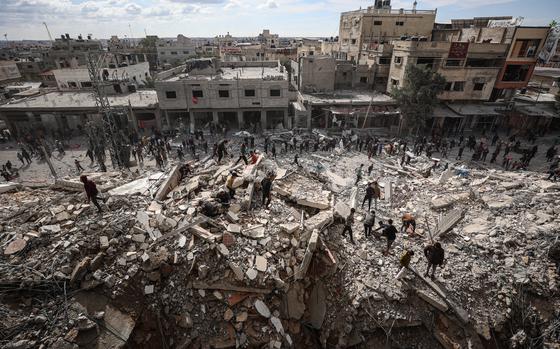 Palestinians inspect their homes after Israeli strikes hit the Al-Masry ...