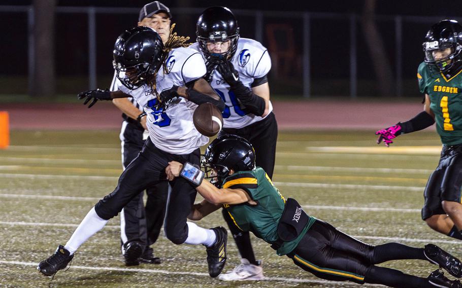 Edgren's Haruki Jones forces the ball out of Osan's Malik Davis' hands. The Cougars suffered six turnovers in their loss to the Eagles.