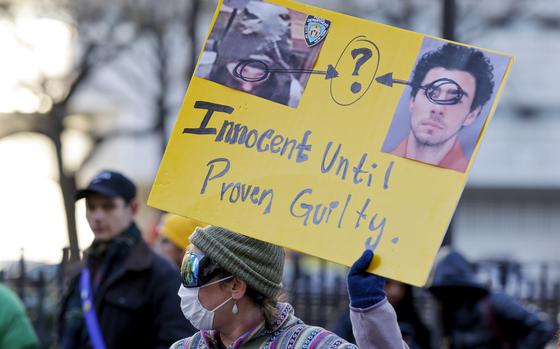 A demonstrator holds up a sign while waiting for the arrival of Luigi Mangione for his arraignment at Manhattan Criminal Court, Monday, Dec. 23, 2024, in New York. (AP Photo/Stefan Jeremiah)