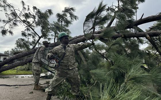 A National Guardsman removes a fallen tree from a road in Morgan City, La. on Thursday, Sept. 12, 2024, after Hurricane Francine passed through. (AP Photo/Jack Brook)  