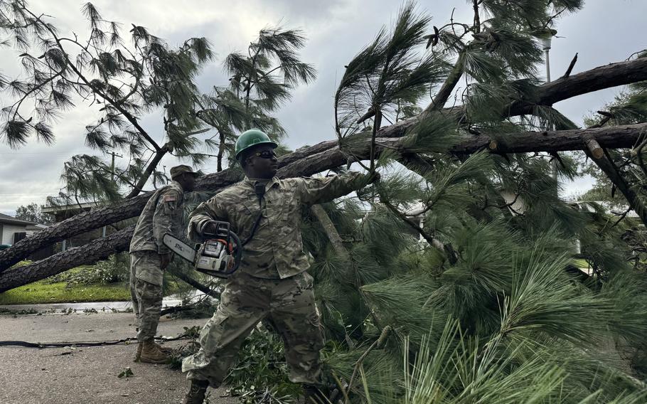 National Guardsman removes fallen tree