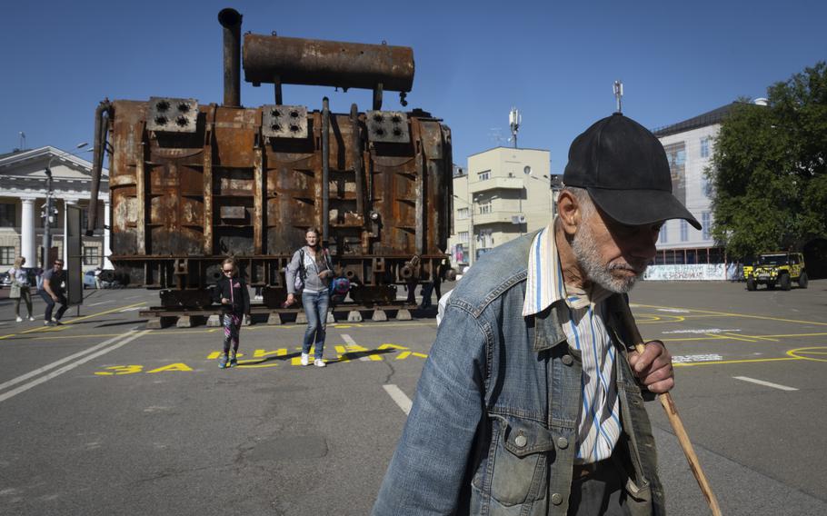 A man passes by a burnt transformer from one of power plants badly damaged