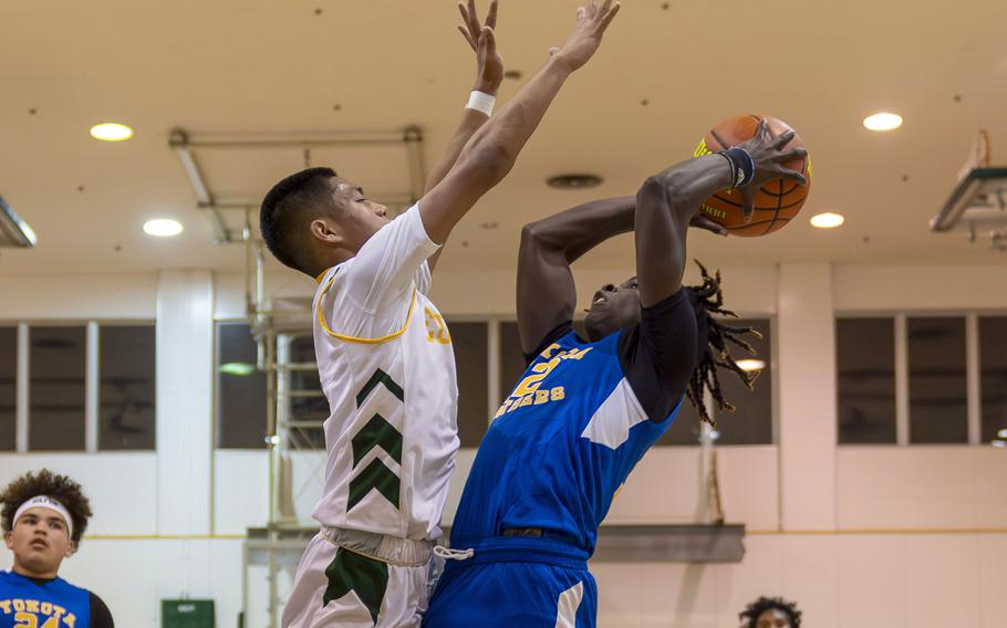 Yokota's Jai Bailey shoots against Robert D. Edgren's P.J. Lorenzo during Friday's DODEA-Japan boys basketball game. The Panthers won 67-57.