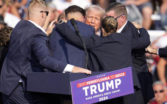 FILE - Republican presidential candidate former President Donald Trump is surrounded by Secret Service at a campaign event in Butler, Pa., July 13, 2024.  A senior FBI official says the gunman in the assassination attempt of former President Donald Trump searched online for events of both Trump and President Joe Biden and saw the Pennsylvania campaign rally where he opened fire last month as a “target of opportunity."  (AP Photo/Gene J. Puskar, File)