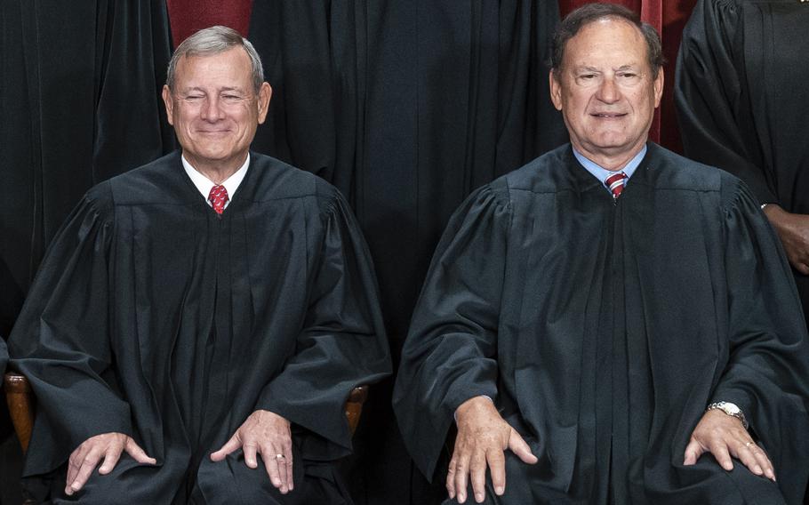 Chief Justice John G. Roberts Jr., left, and Associate Justice Samuel A. Alito Jr. sit for a group photo at the Supreme Court in 2022. 
