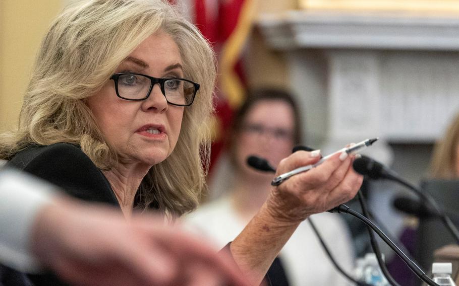 Sen. Marsha Blackburn sits in a hearing, lifting her right hand and pointing with a pen as she speaks.