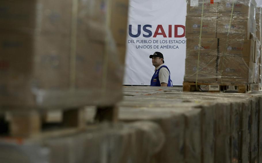 A man walks past boxes of USAID humanitarian aid at a warehouse at the Tienditas International Bridge on the outskirts of Cucuta, Colombia, Feb. 21, 2019, on the border with Venezuela. 