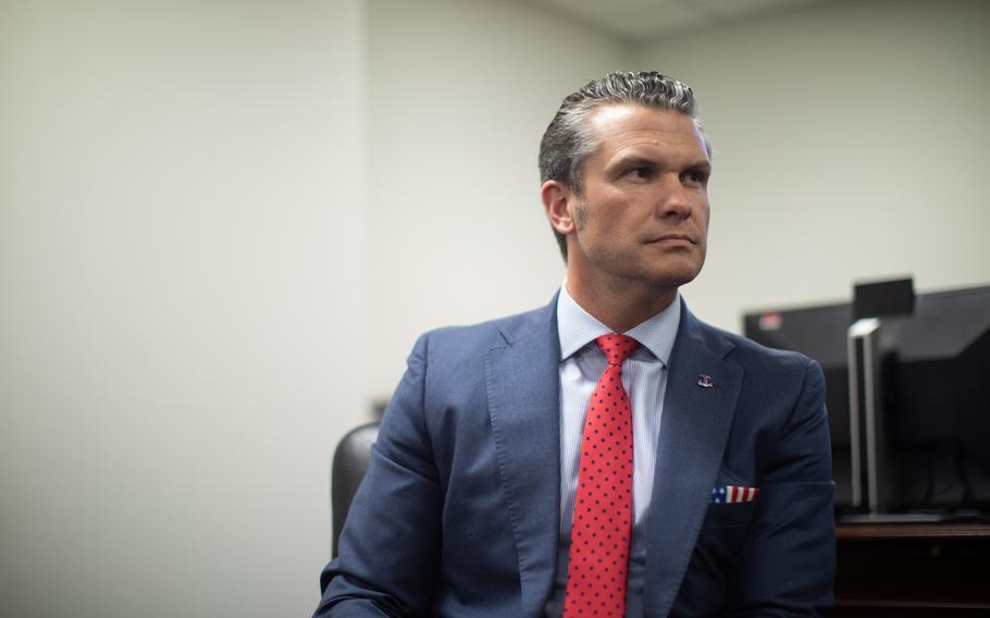 Hegseth in a blue suit and a red tie.