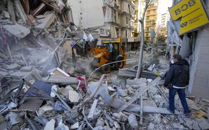 Rescue workers use a bulldozer to remove rubble of destroyed buildings at the site of an Israeli airstrike on Sunday night that hit several branches of the Hezbollah-run al-Qard al-Hassan in Beirut's southern suburb, Lebanon, Monday, Oct. 21, 2024. (AP Photo/Hassan Ammar)