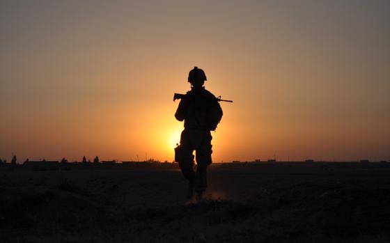 Mosul, Iraq, Aug. 20, 2010: An American soldier patrols at sunset outside of Mosul. 