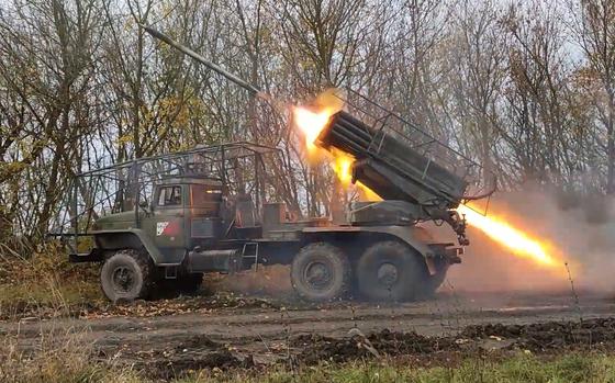 Flames shoot out the back of a truck-mounted rocket launcher as it fires a shell.