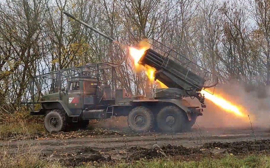 Flames shoot out the back of a truck-mounted rocket launcher as it fires a shell.