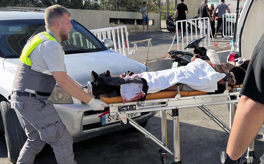 A Civil Defense first-responder carries a wounded man whose handheld pager exploded at al-Zahraa hospital in Beirut