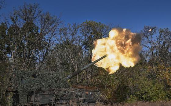 A self-propelled howitzer fires a round.