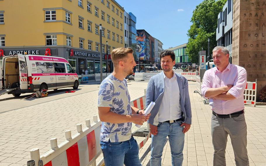 Project manager Jörg Riedinger, left, Manuel Steinbrenner, the city building director, and Sebastian Staab, the head of the civil engineering office, review the newly completed embossed asphalt on Fruchthallstrasse in Kaiserslautern’s city center redevelopment. The final phase of construction is set to begin on Burgstrasse in mid-July.
