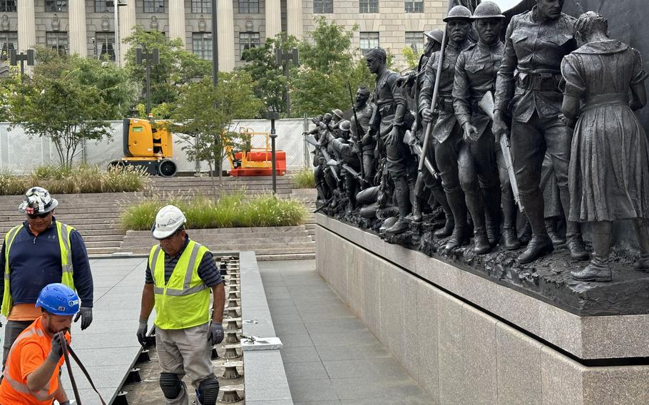 Workers put the finishing touches on the area around sculptor Sabin Howard’s “A Soldier’s Journey” at the National World War I Memorial