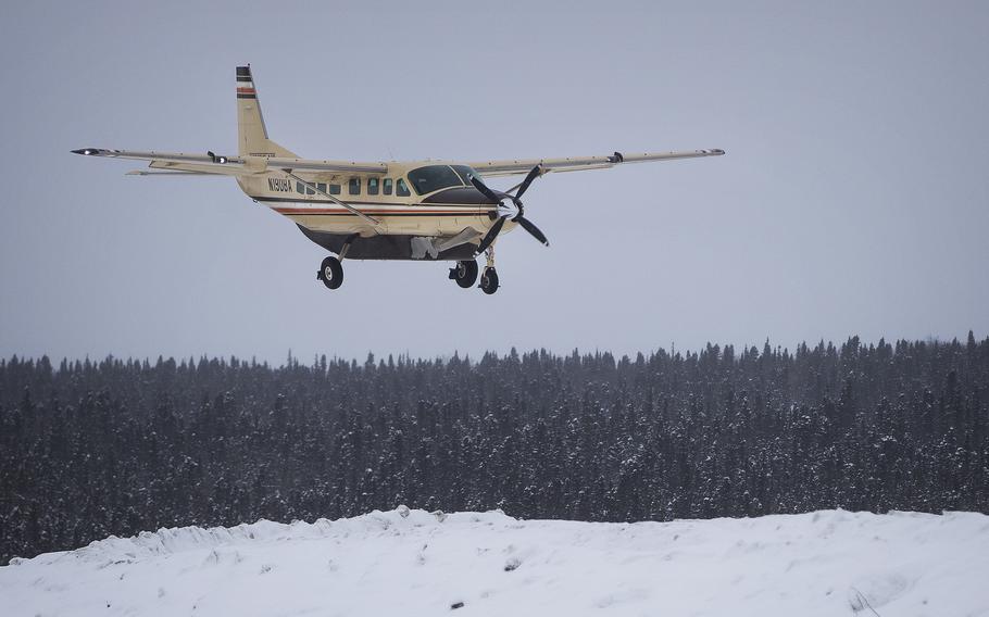 An airplane prepares to land in snow-covered Alaska.