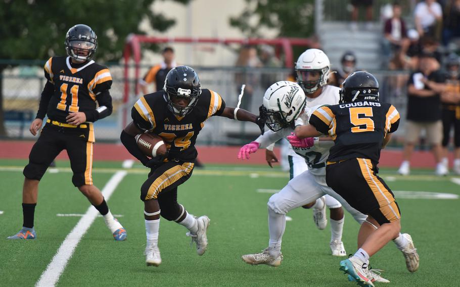 Vicenza’s Davon Gann shoves away a Naples defender Friday, Sept. 20, 2024, while making a short gain in the Cougars’ 28-6 loss to the Wildcats.