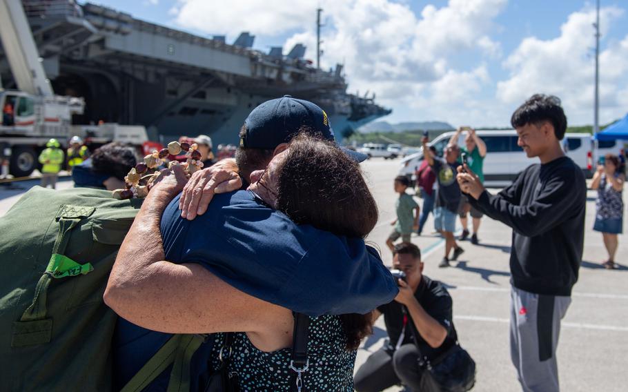 Petty Officer 1st Class Nathan Rupley, from Dededo, Guam, greets family members on the pier after the USS Ronald Reagan pulled into Naval Base Guam for a scheduled port visit June 19, 2024.