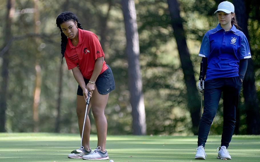 Kaiserslautern junior Asia Andrews putts on the 12th green during the second day of the DODEA European golf championships on Oct. 13, 2023, at Woodlawn Golf Course on Ramstein Air Base, Germany. Watching, at right, is Ramstein’s Nora Hacker.