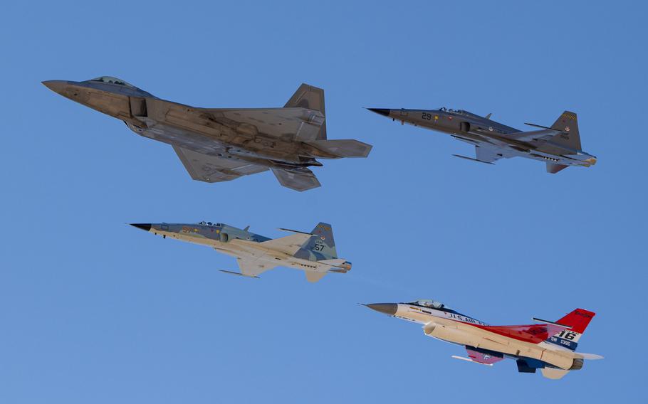 Four aircraft in flight, blue sky above.