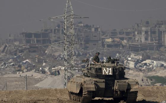 Israeli soldiers overlook the Gaza Strip from a tank.