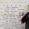 An American Battle Monuments Commission staff member places a bronze rosette next to the name of U.S. Army Pfc. Alcario V. Flores on the Wall of the Missing on July 23, 2024, at the Epinal American Cemetery in Dinozé, France. The rosette signifies that Flores has been accounted for.