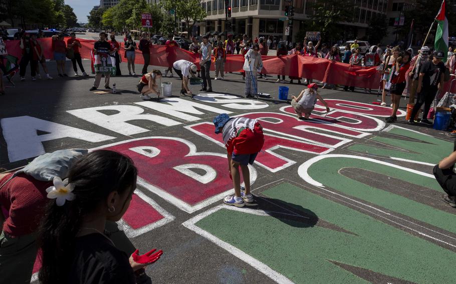 Demonstrators paint a sign on the street that reads “arms embargo now” near the White House on Saturday.