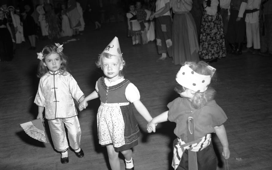 Children dressed up in their Halloween costumes hold hands as they form a parade during the Halloween celebration Oct. 30, 1948.