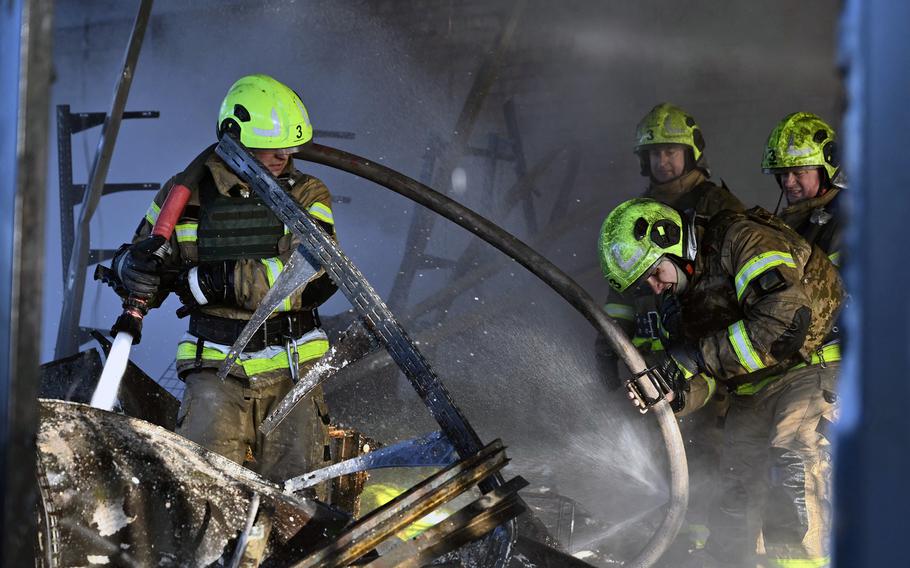 Ukrainian rescuers work to extinguish a fire