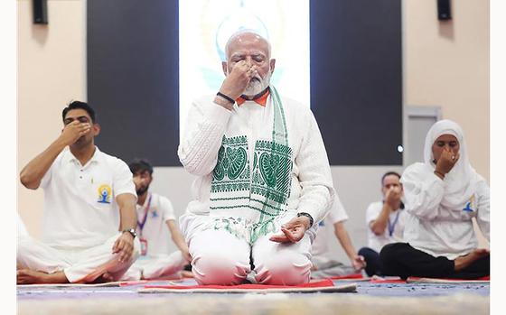 In this handout photograph taken and released on June 21, 2024, by the Indian Press Information Bureau (PIB), India's Prime Minister Narendra Modi performs asana on International Day of Yoga in Srinagar. (PIB/AFP via Getty Images/TNS)