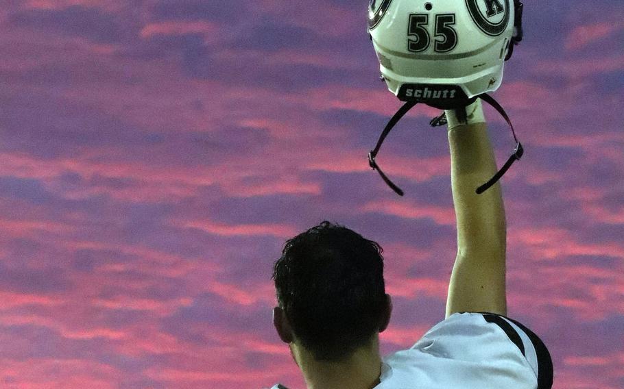 Kubasaki senior lineman Nathan Reeves holds his helmet aloft following Friday's football game at Kadena. The Dragons won the season opener over the Panthers for the second straight year 14-13.