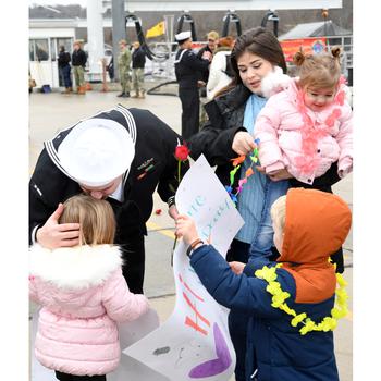 A sailor embraces his loved ones