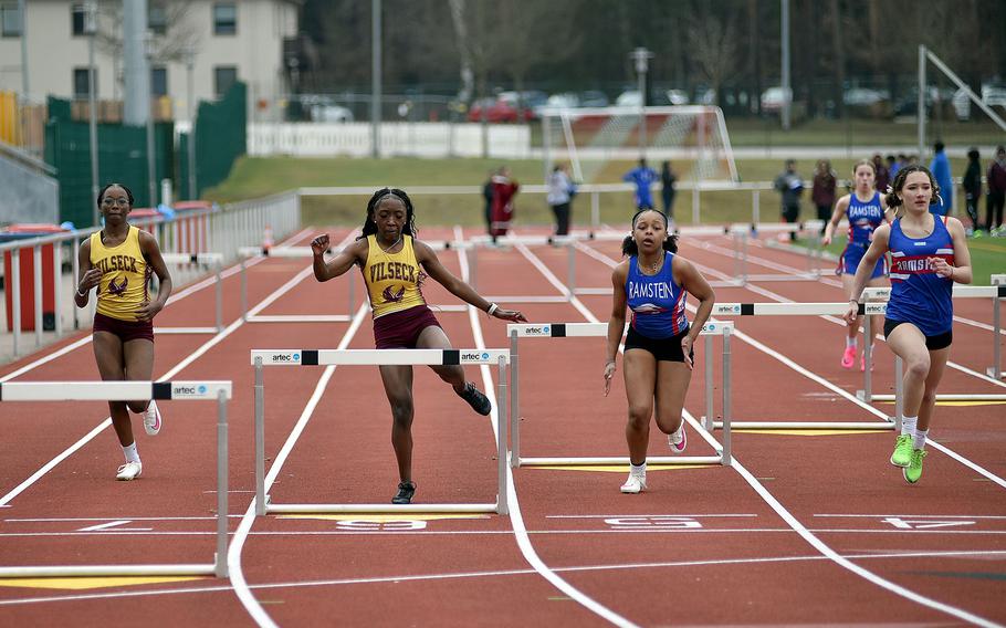 Athletes run in the 300-meter hurdles.