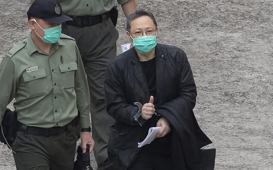 Former law professor Benny Tai, a key figure in Hong Kong's 2014 Occupy Central protests and also was one of the main organizers of the primaries, who was arrested under Hong Kong's national security law, gives the thumbs up as he is escorted by Correctional Services officers in Hong Kong March 2, 2021. A Hong Kong court began mitigation hearings for prominent pro-democracy activists who were convicted under a national security law and now face up to life in prison.