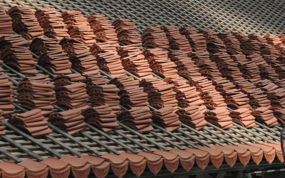 Tiles made of mudstone and red clay are placed on the roof of Shuri Castle's main hall in Naha, Okinawa, on July 15, 2024. 