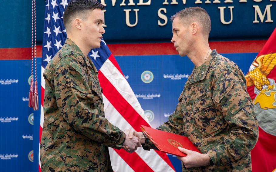 Two Marines shakes hands and look at each other during an award ceremony