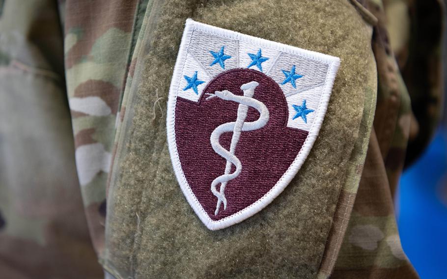 The 68th Theater Medical Command patch was given to troops for the first time on Sept. 20, 2024. It includes the staff of Asclepius, the god of medicine, and a horizon emitting sun rays, which represent a guiding light. The five blue stars allude to authority and leadership within the command. The colors maroon and white represent the Army Medical Department.