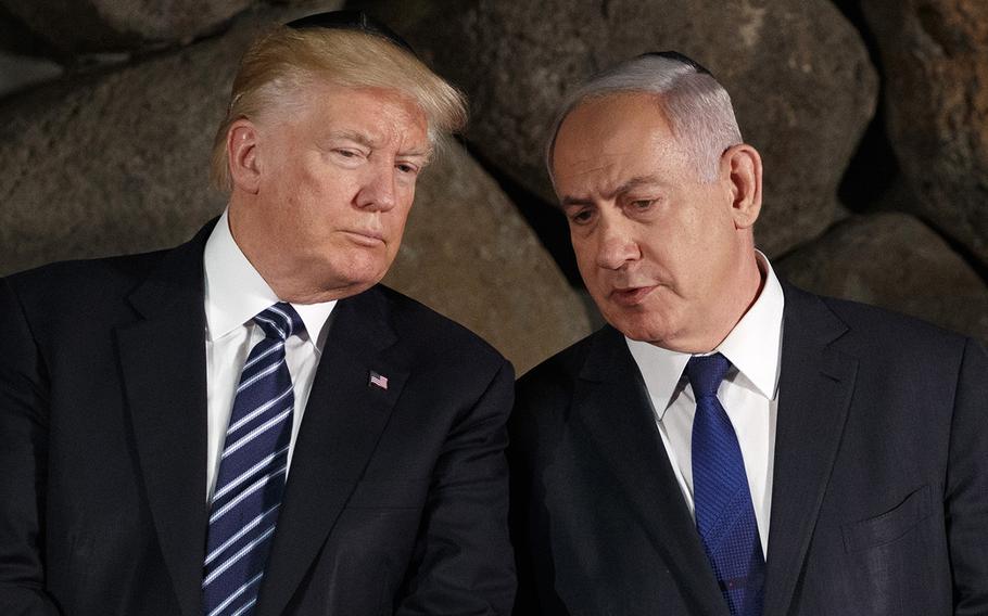 Donald Trump sits next to Benjamin Netanyahu.