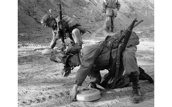 Somewhere in the mountains, South Korea, Jan. 5, 1962: Privates First Class Robert Andalis (front) and John Barnes of A Company, 2nd Battle Group, 12th Cavalry Regiment check and defuse landmines found on the road. 

The men of the 12th Cavalry Regiment participated in a month-long Army training test. The training, which began Jan. 2, is held in the mountain areas of South Korea where the cavalrymen honed their skills in varied terrains such as jungles and expansive open agricultural paddies. Part of the combat exercise was devoted to learning to spot and defuse so-called boobytraps - often hidden anti-personnel mines. 

Looking for Stars and Stripes’ historic coverage? Subscribe to Stars and Stripes’ historic newspaper archive! We have digitized our 1948-1999 European and Pacific editions, as well as several of our WWII editions and made them available online through https://starsandstripes.newspaperarchive.com/

META TAGS: 12th Cavalry Regiment; 1st Cavalry Division; U.S. Army; boobytrap; booby trap; IED; improvised explosive device; mine; anti-personnel mine