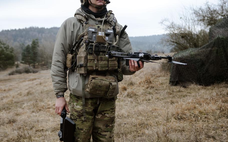 A soldier pilots a drone. 