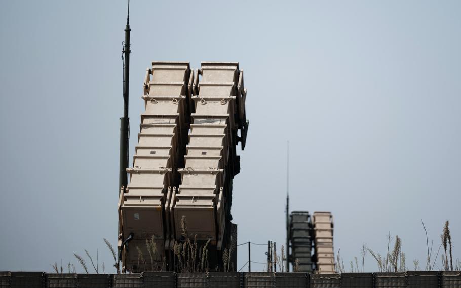 Army Patriot missile launchers against a blue sky.