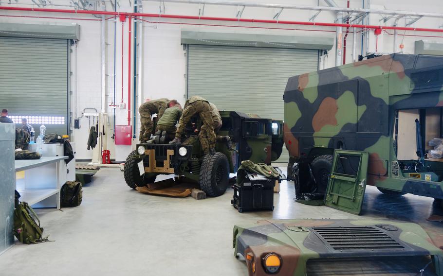 Polish troops fix a tank recovery vehicle at a warehouse in Poland.        