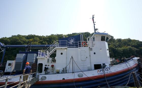 A worker stands near the NH3 Kraken, a tugboat powered by ammonia, on Friday, Sept. 13, 2024, in Kingston, N.Y. (AP Photo/Alyssa Goodman)