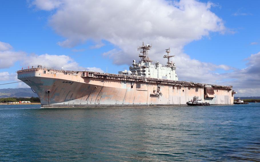 The decommissioned USS Tarawa, an amphibious assault ship, is escorted out of Pearl Harbor to the open sea during the Rim of the Pacific exercise on July 16, 2024.