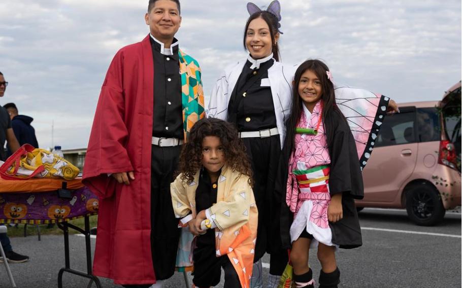 A family poses for a photo during the III Marine Expeditionary Force Support Battalion, III Marine Expeditionary Force’s trunk-or-treat event at Camp Courtney, Okinawa, Japan, Oct. 27, 2023. The event invited all service members and their families to dress up, decorate their vehicles, and celebrate Halloween to promote a positive community within the installation.