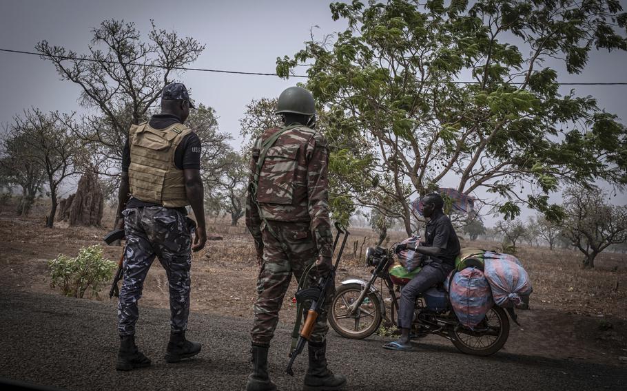 A police officer and a soldier from Benin stop a motorcyclist at a checkpoint outside Porga, Benin, March 26, 2022. Jihadi fighters who had long operated in Africa’s volatile Sahel region have settled in northwestern Nigeria after crossing from neighboring Benin, a new report said Wednesday, June 19, 2024, the latest trend in the militants’ movements to wealthier West African coastal nations. 