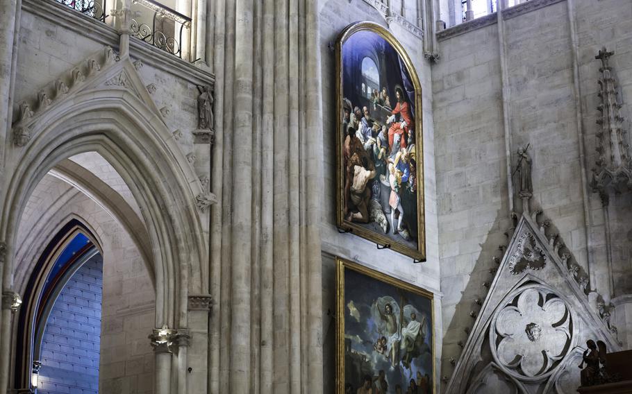 Colorful works of art line the stone wall of a gothic church.