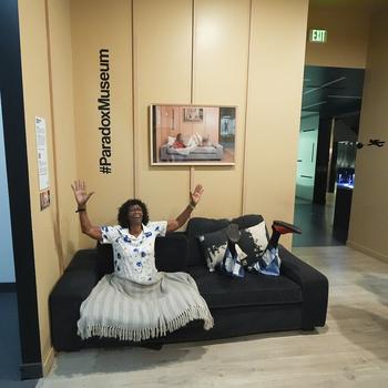 A woman sits on the Paradox Couch at Paradox Museum Miami.